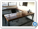The large U shaped executive desk was built from 2" thick reclaimed spruce from a building in Worcester MA.  The wood was skip planed and sealed with multiple coats of clear polyurethane. The welded steel frame was made using 2" square steel tubing.